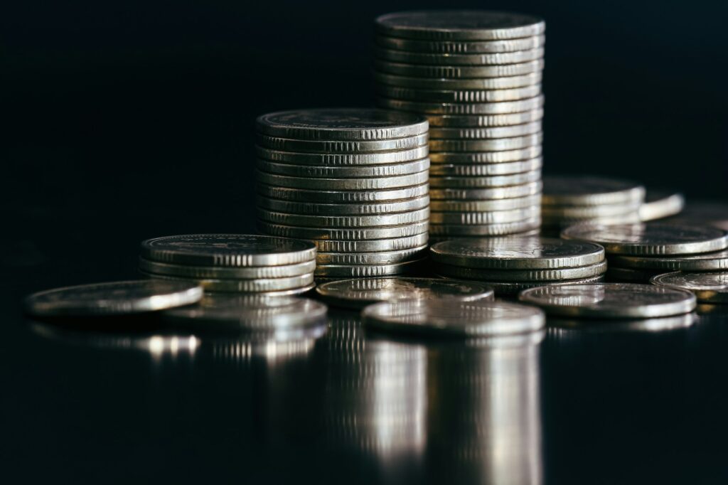 Close up of silver money coin stack on black background with selective focus to illustrate adding a listing to sound money